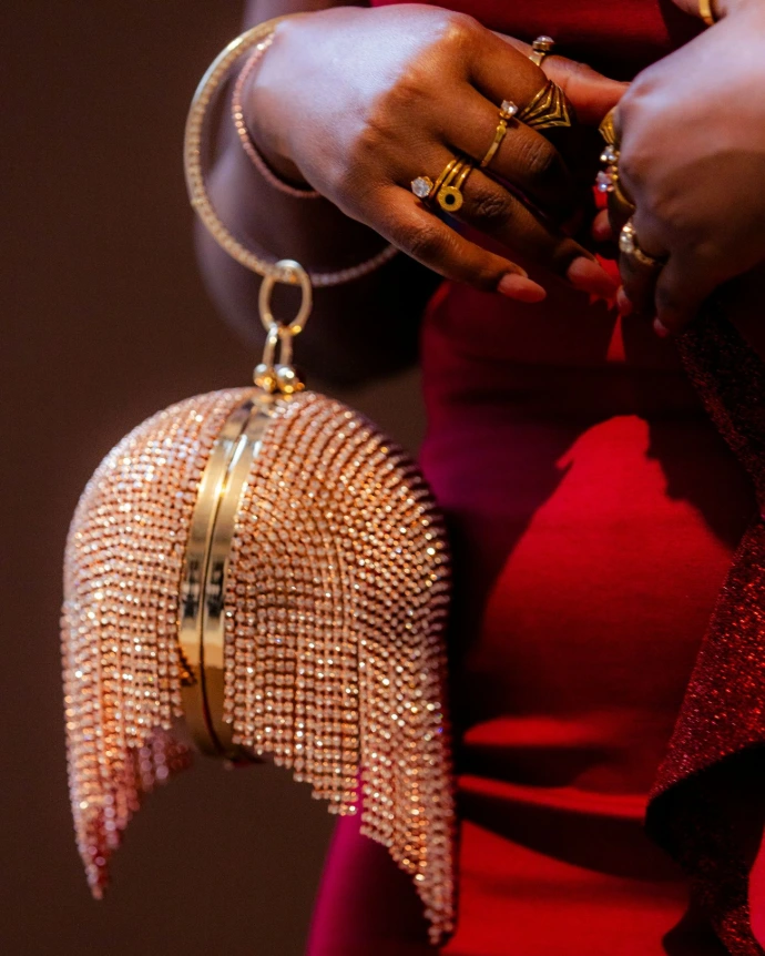 A woman holds a bedazzled handbag.